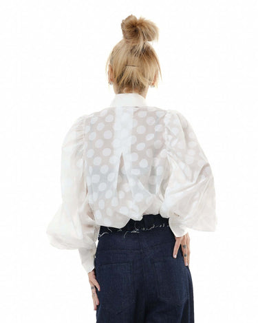 Back view of a white shirt with sheer polka dots and puff sleeves, highlighting the elegant design and lightweight fabric.