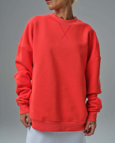 Vibrant red oversized sweatshirt worn by a model, showcasing stylish streetwear and urban fashion.