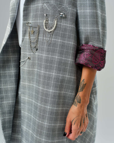 Light grey checked blazer featuring decorative chains and a burgundy paisley lining on the rolled sleeves.