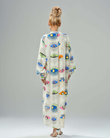 Back view of a woman in a vibrant eye print shirt dress, featuring ¾ sleeves and a loose, lightweight design.