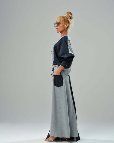 Stylish woman in grey and denim co-ord set featuring relaxed sweatshirt and flowing maxi skirt, showcasing modern fashion.