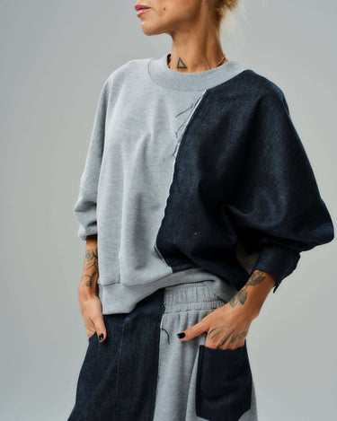 Model wearing a contemporary grey and denim co-ord set featuring a relaxed sweatshirt and flowing maxi skirt.