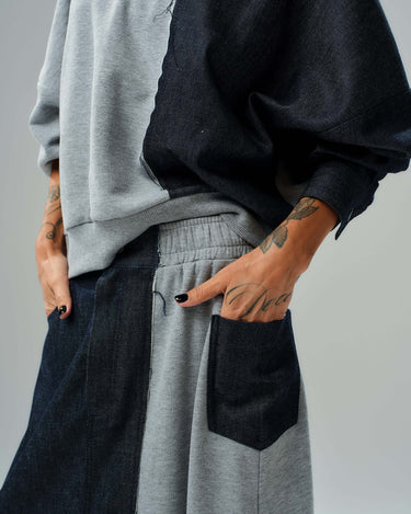 Close-up of a grey and denim co-ord set featuring a relaxed sweatshirt and flowing maxi skirt with contrasting textures.