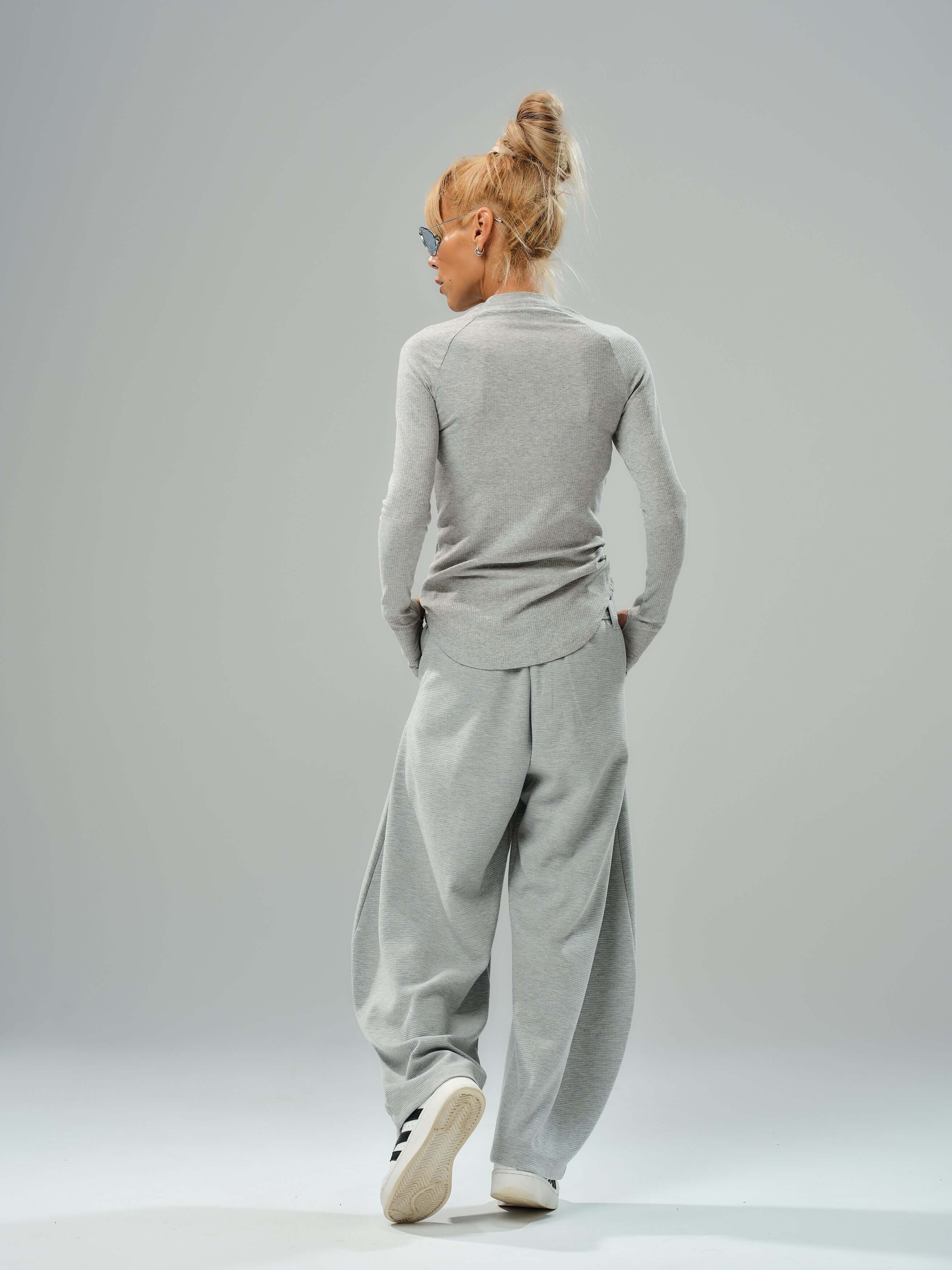 Model wearing a fitted long-sleeve gray top and oversized gray wide-leg trousers from the three-piece set.