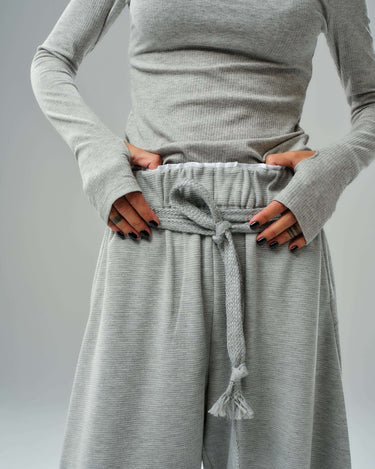 Close-up of oversized grey three-piece set featuring a fitted long-sleeve top and wide-leg drawstring trousers.