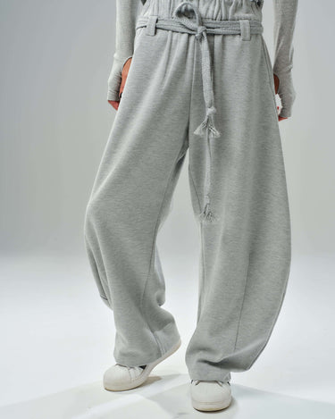 Oversized grey wide-leg drawstring trousers from a three-piece cotton blend set, perfect for relaxed styling.
