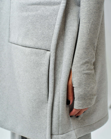 Detail of oversized grey sleeveless vest with large pockets and fitted long-sleeve top from three-piece cotton blend set.
