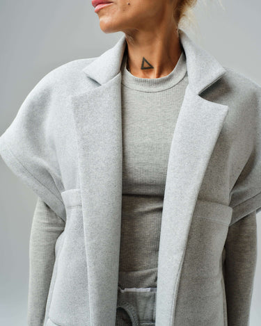 Model wearing an oversized grey three-piece set, featuring a soft cotton blend vest and fitted long-sleeve top.