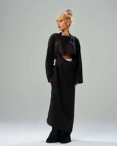 Model wearing a stylish black co-ord set featuring a long tunic and wide-leg pants, showcasing modern minimalism.