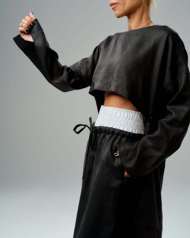 Black co-ord set featuring a cropped tunic and wide-leg pants with elastic waistband and drawstring for adjustable fit.