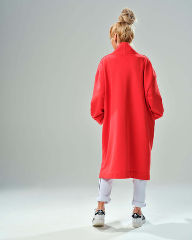 Back view of a woman wearing a red oversized coat with a relaxed fit, showcasing its stylish and comfortable design.