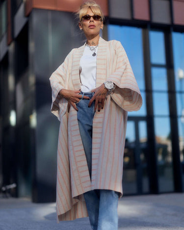 Model wearing a striped linen-cotton kimono over a white tee and jeans, showcasing a casual, elegant look.