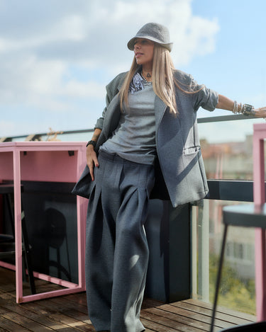 Model wearing a Gray Oversized Blazer with relaxed fit, paired with wide-leg trousers and a stylish hat.