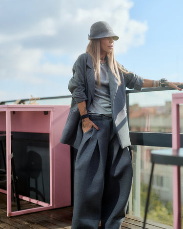 Model showcasing a Gray Oversized Blazer styled with wide pants on a balcony, offering a chic and relaxed look.