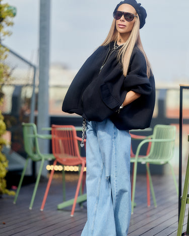 Black Oversized Textured Jacket worn with wide-leg jeans and sunglasses on a rooftop.
