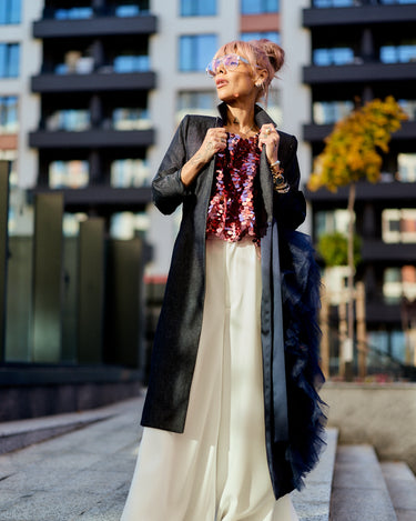 Woman wearing a Denim Tulle Detail Blazer with tulle ruffle, showcasing a modern urban style in an outdoor setting.