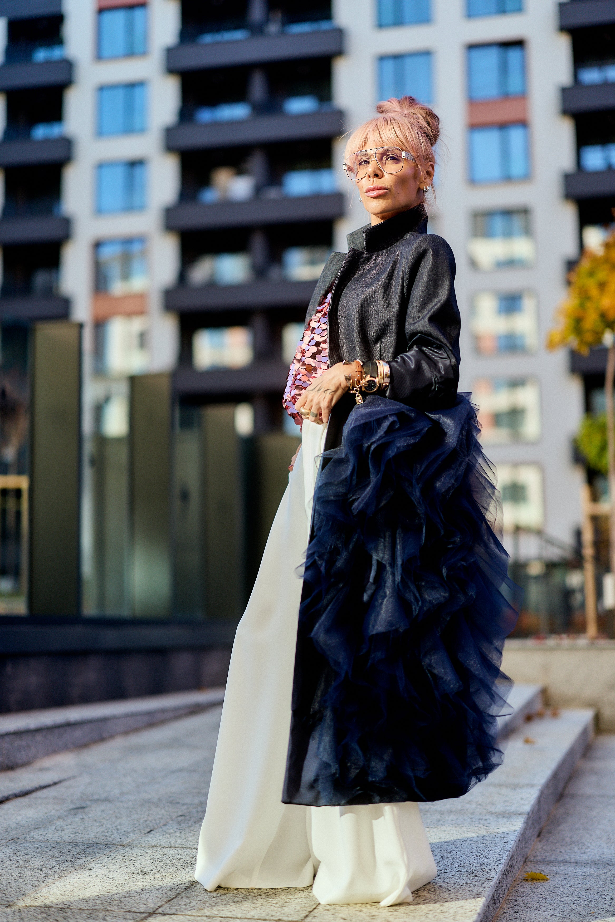 Woman wearing Denim Tulle Detail Blazer with tulle ruffle standing in city setting.