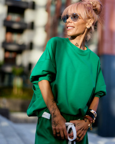 Green Oversized Sweat Set with Open Back showcased in urban setting on a model with sunglasses and stylish accessories.