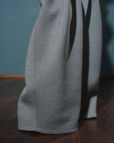 Gray Wide-Leg Structured Pants showcasing their sculptural design and textured fabric on wooden floor.