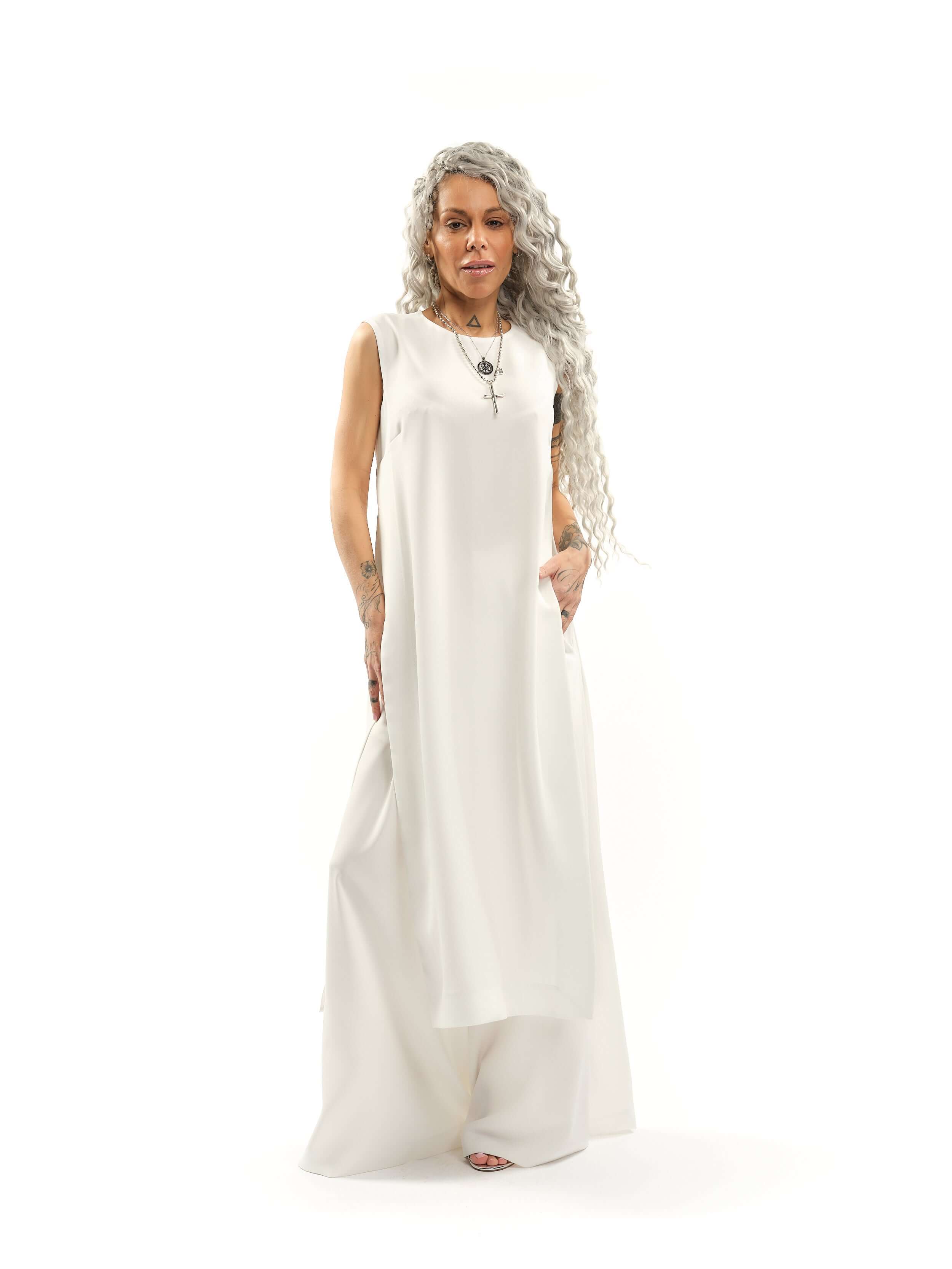 Sleeveless Maxi Tunic Suspended from barely-there straps that crisscross and tie at the back, this dress drapes fluidly, catching movement with every step. The midi length strikes the perfect balance between elegance and ease. FEATURES:Black midi dress wi