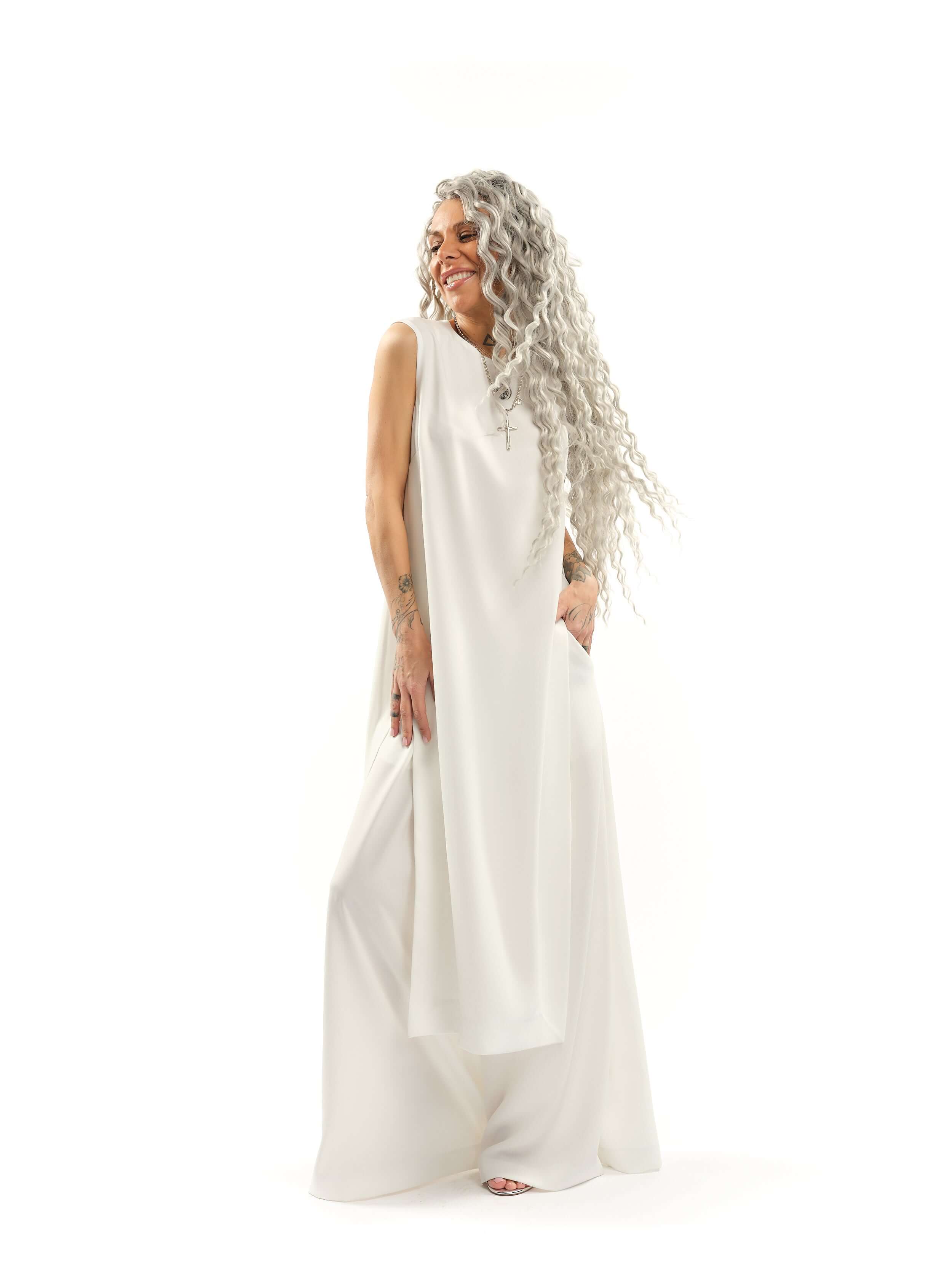 Sleeveless Maxi Tunic Suspended from barely-there straps that crisscross and tie at the back, this dress drapes fluidly, catching movement with every step. The midi length strikes the perfect balance between elegance and ease. FEATURES:Black midi dress wi