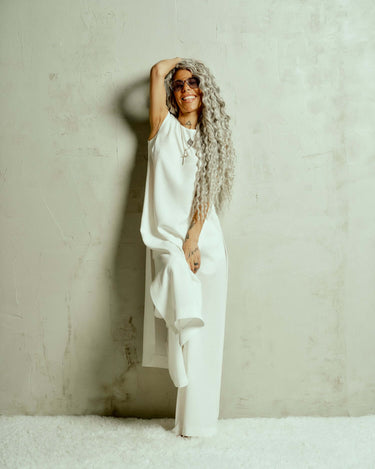 Sleeveless Maxi Tunic Suspended from barely-there straps that crisscross and tie at the back, this dress drapes fluidly, catching movement with every step. The midi length strikes the perfect balance between elegance and ease. FEATURES:Black midi dress wi