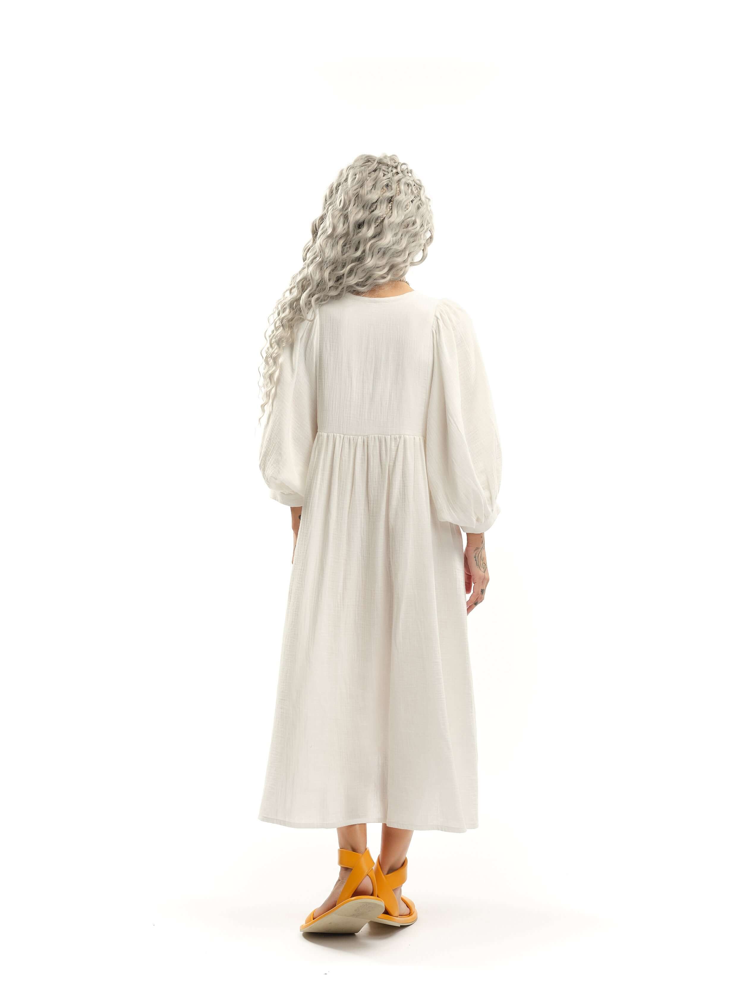 Cotton-Blend Midi Dress Designed with a relaxed, babydoll silhouette, this dress drapes effortlessly, letting the fabric move with ease. The billowing sleeves fall just above the wrists, adding a touch of structure to the fluid shape, while the v-neckline