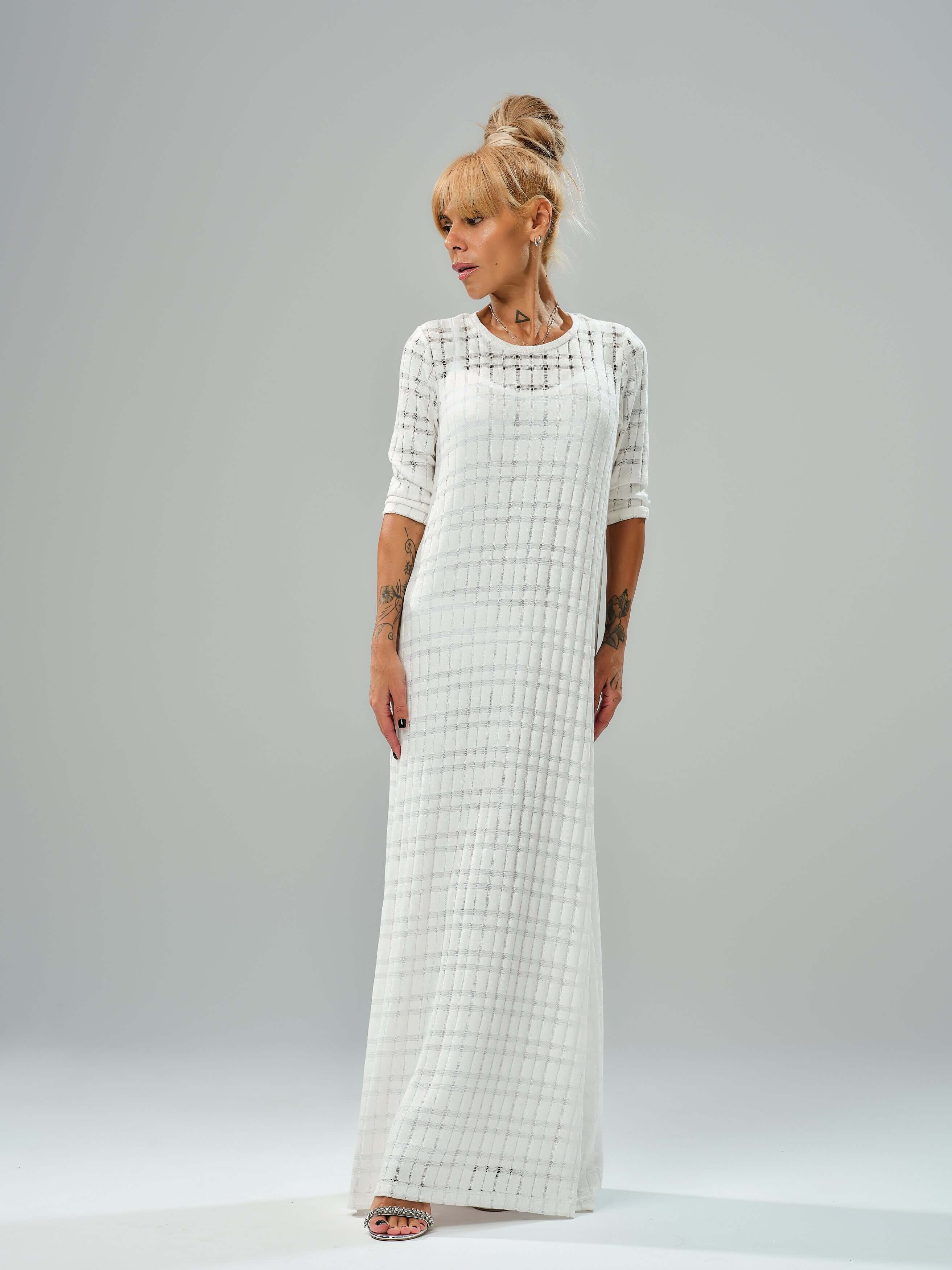Graceful white knitted cotton dress with semi-sheer texture and asymmetrical layered cut, perfect for casual and evening wear.