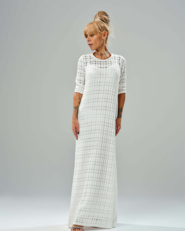 Graceful white knitted cotton dress with semi-sheer texture and asymmetrical layered cut, perfect for casual and evening wear.