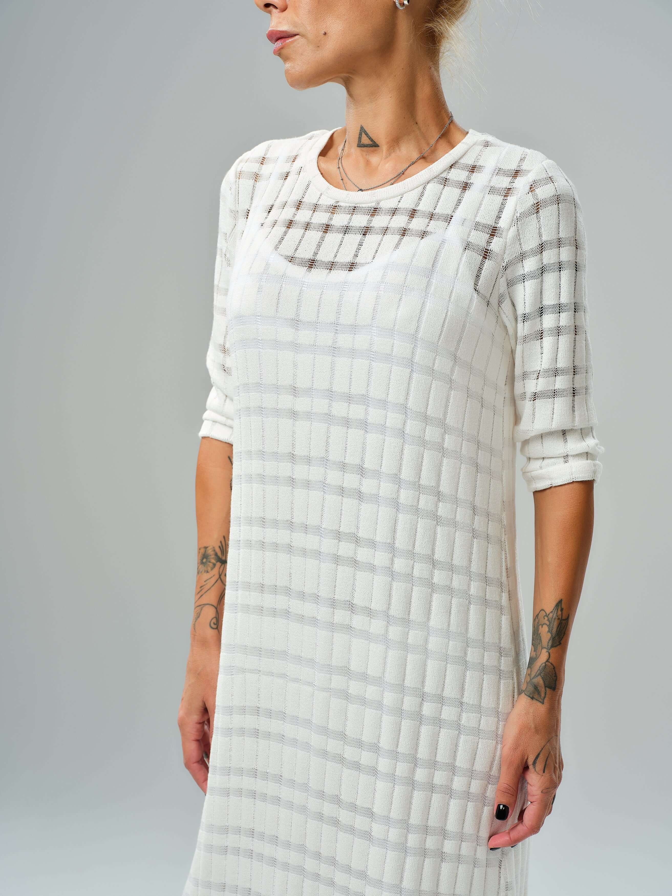 White knitted cotton dress featuring a semi-sheer texture and asymmetrical layered cut for elegant styling.