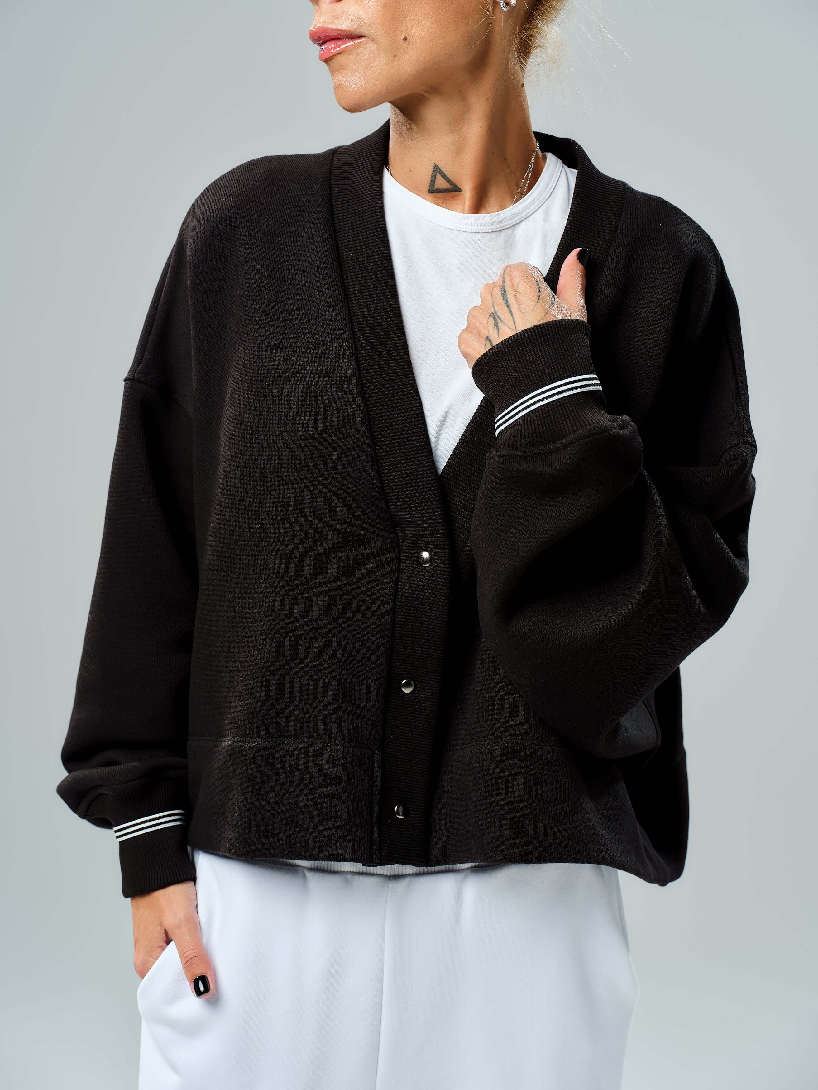 Black snap-button jacket with a relaxed silhouette, featuring dropped shoulders and ribbed cuffs, perfect for stylish layering.