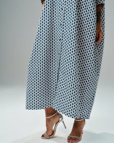 Model wearing oversized shirt dress with blue micro floral print, showcasing relaxed silhouette and elegant sandals.
