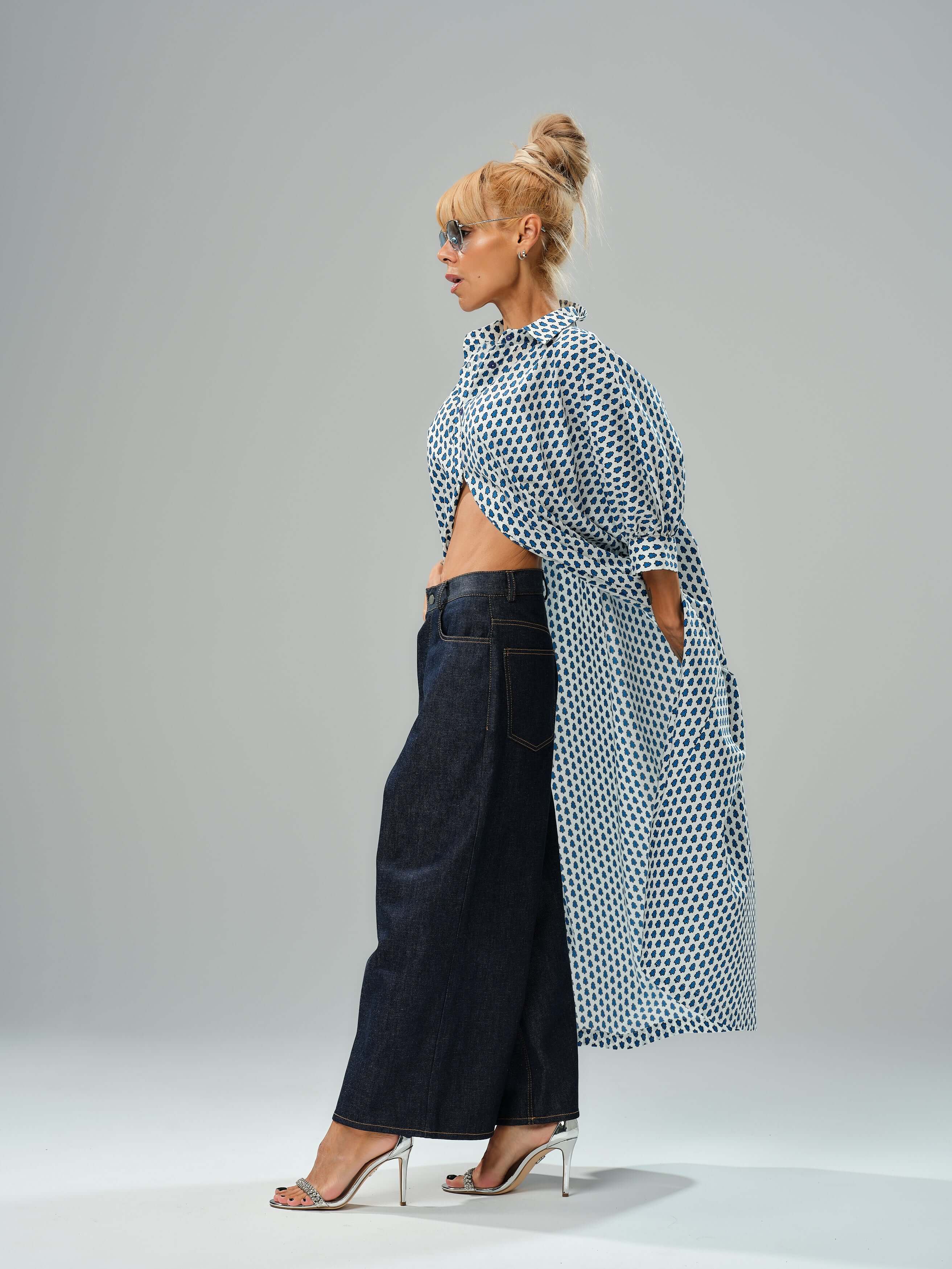Model showcasing wide-leg denim jeans with a polka dot shirt, highlighting a modern and stylish outfit.