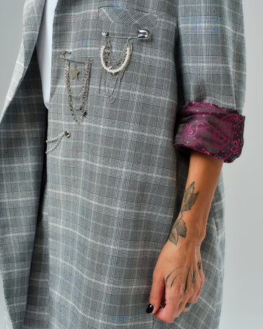 Light grey checked blazer featuring decorative chains and a burgundy paisley lining on the rolled sleeves.