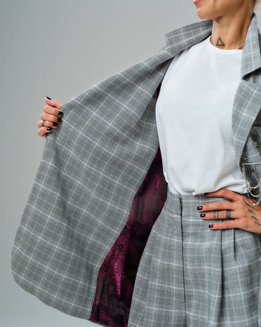 Light grey checked blazer with burgundy paisley lining, worn over a white top, showcasing its stylish interior.