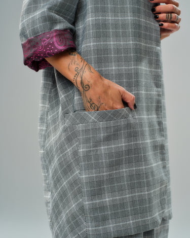 Close-up of checked blazer showcasing pocket and burgundy paisley lining detail.