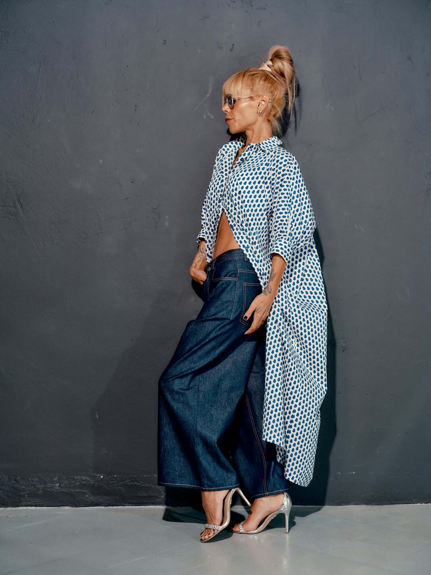 Fashionable model in wide-leg denim jeans and oversized shirt, showcasing modern style and comfort.