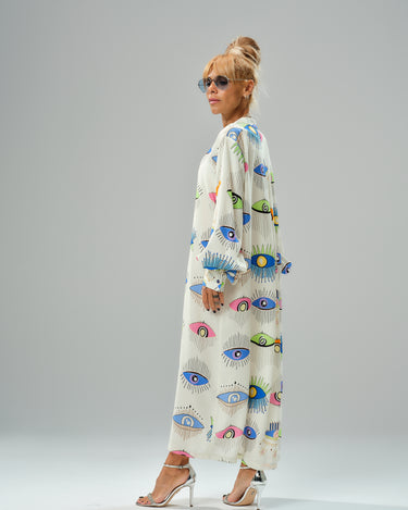 Woman wearing a vibrant eye print shirt dress, showcasing modern style with a loose fit and ¾ sleeves.