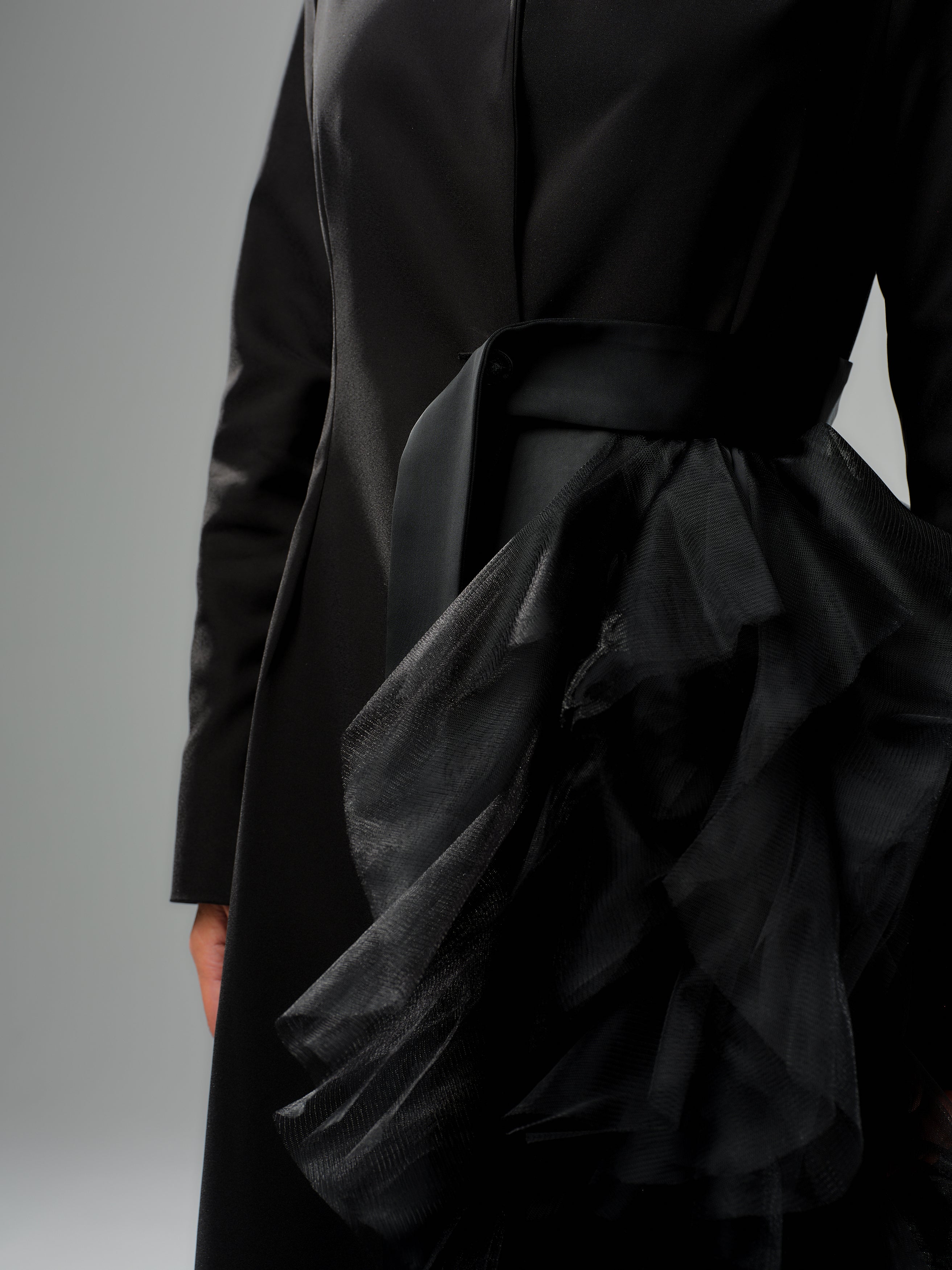 Black tulle detail blazer with asymmetric tulle accent and satin waist belt, showcasing bold evening wear style.