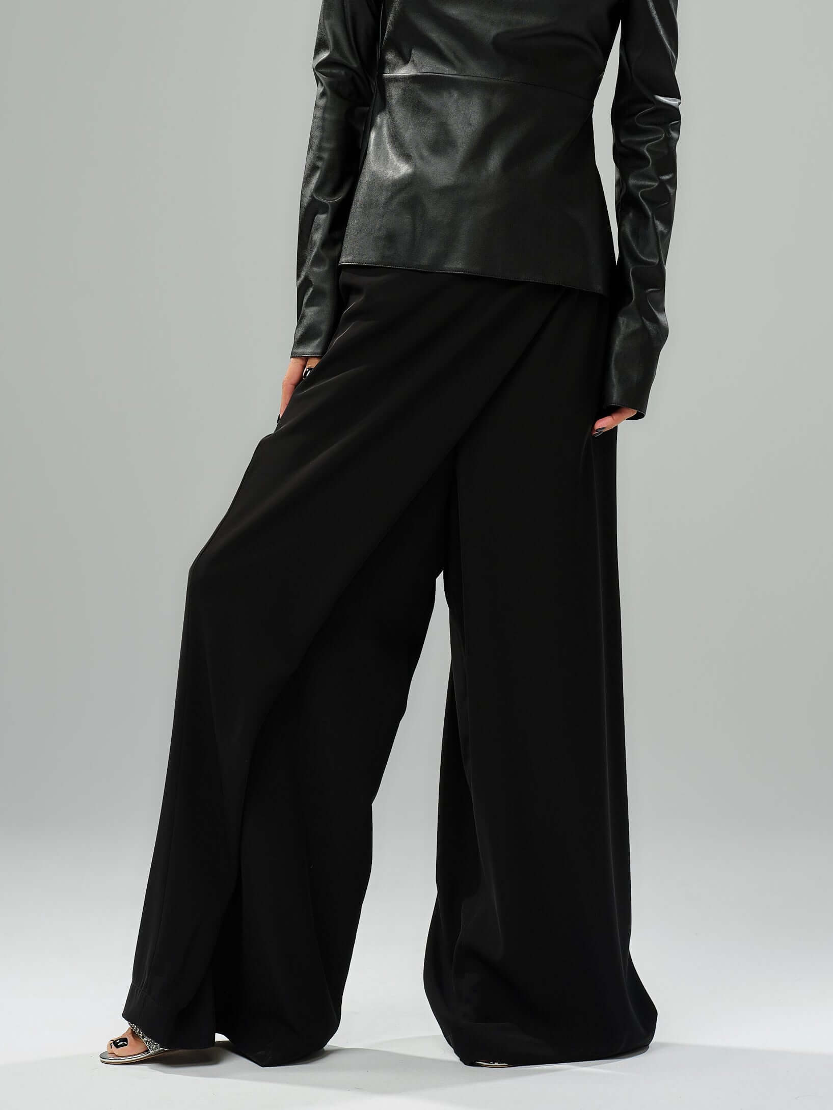 Elegant black wide-leg pants featuring a wrap-effect front and perfect for day or evening styling.