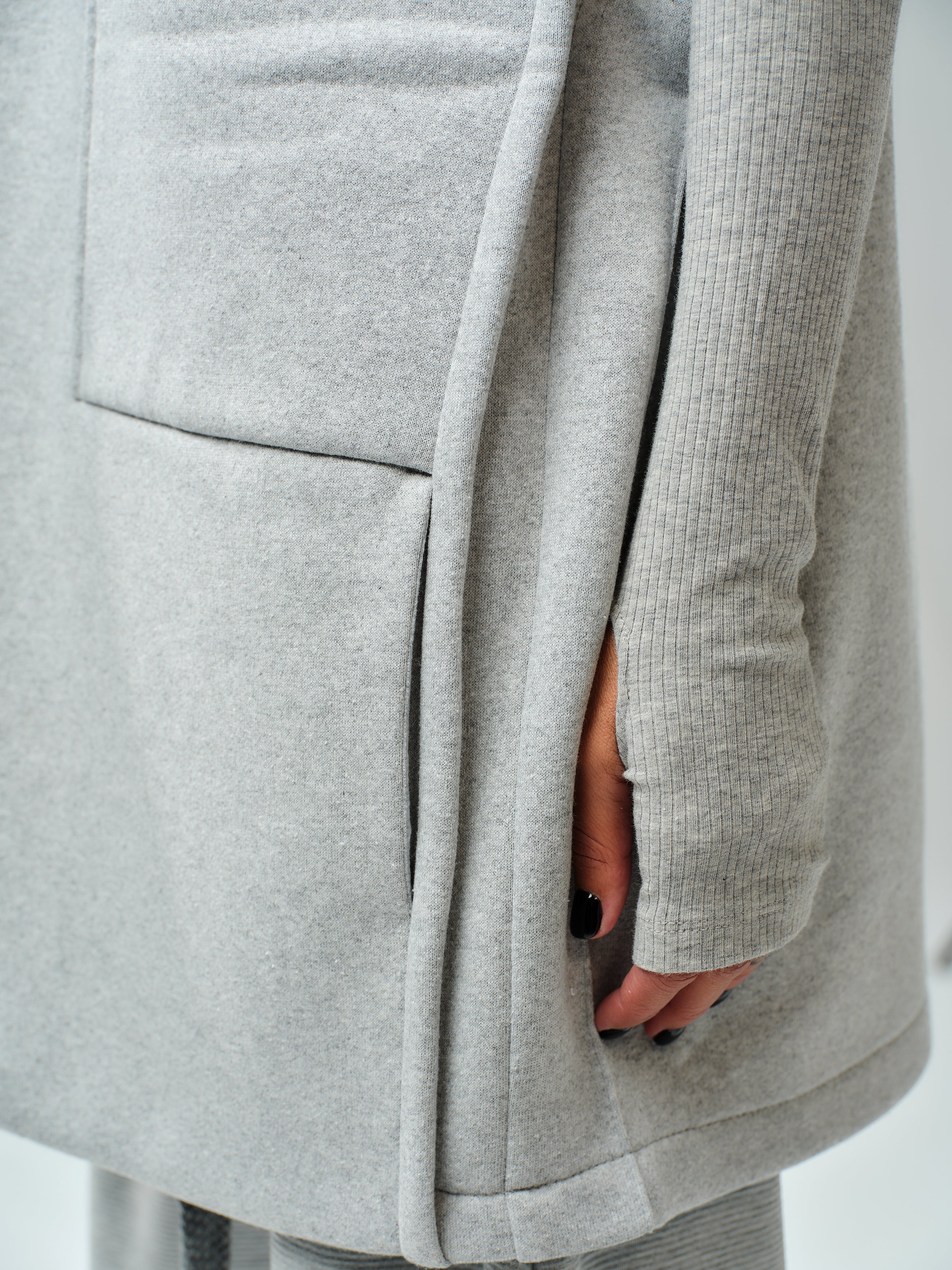 Close-up of grey sleeveless coat showcasing oversized pocket and soft fabric, perfect for casual outfits.