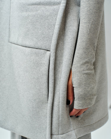 Close-up of grey sleeveless coat showcasing oversized pocket and soft fabric, perfect for casual outfits.