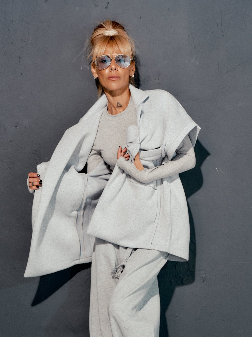 Fashionable grey sleeveless coat in casual streetwear look, featuring oversized pockets and clean lines.