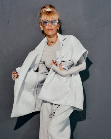 Fashionable grey sleeveless coat in casual streetwear look, featuring oversized pockets and clean lines.