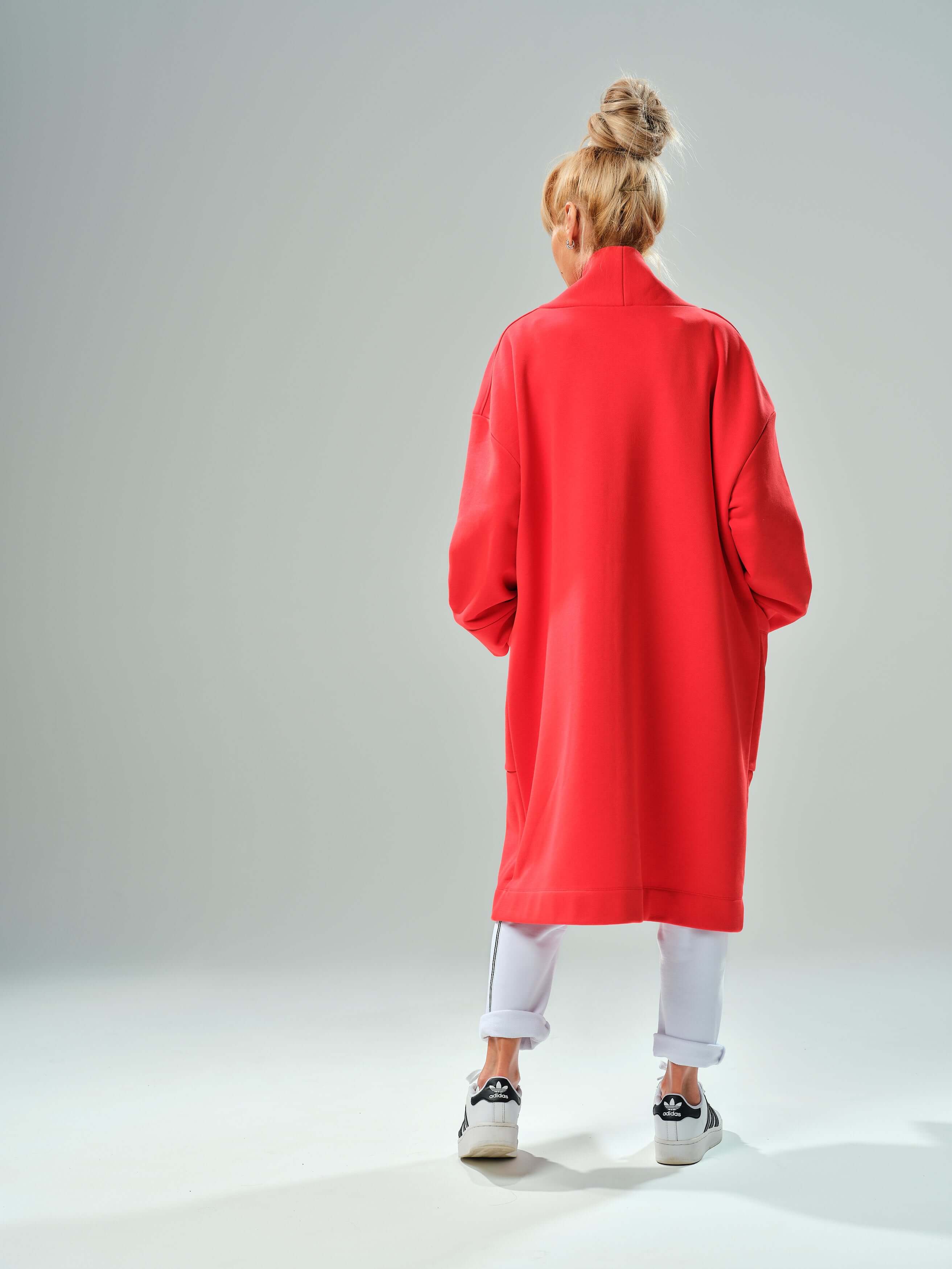 Back view of a woman wearing a red oversized coat with a relaxed fit, showcasing its stylish and comfortable design.