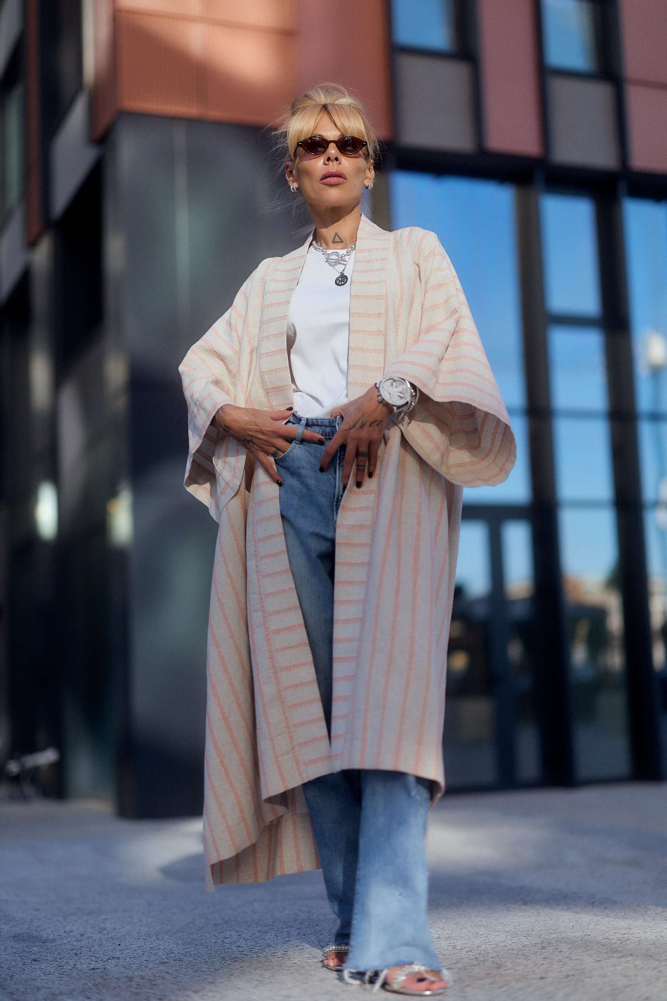 Model wearing a striped linen-cotton kimono over a white tee and jeans, showcasing a casual, elegant look.