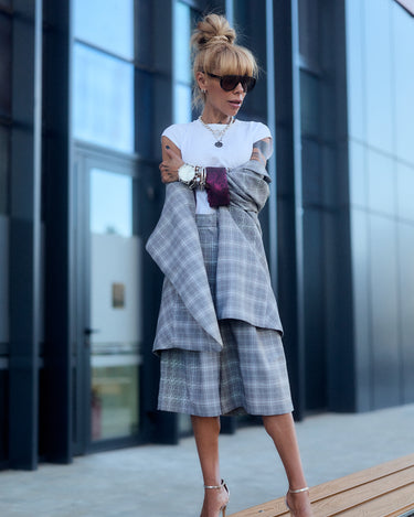 Model wearing a light grey checked blazer and culotte co-ord set with oversized fit and burgundy detail.