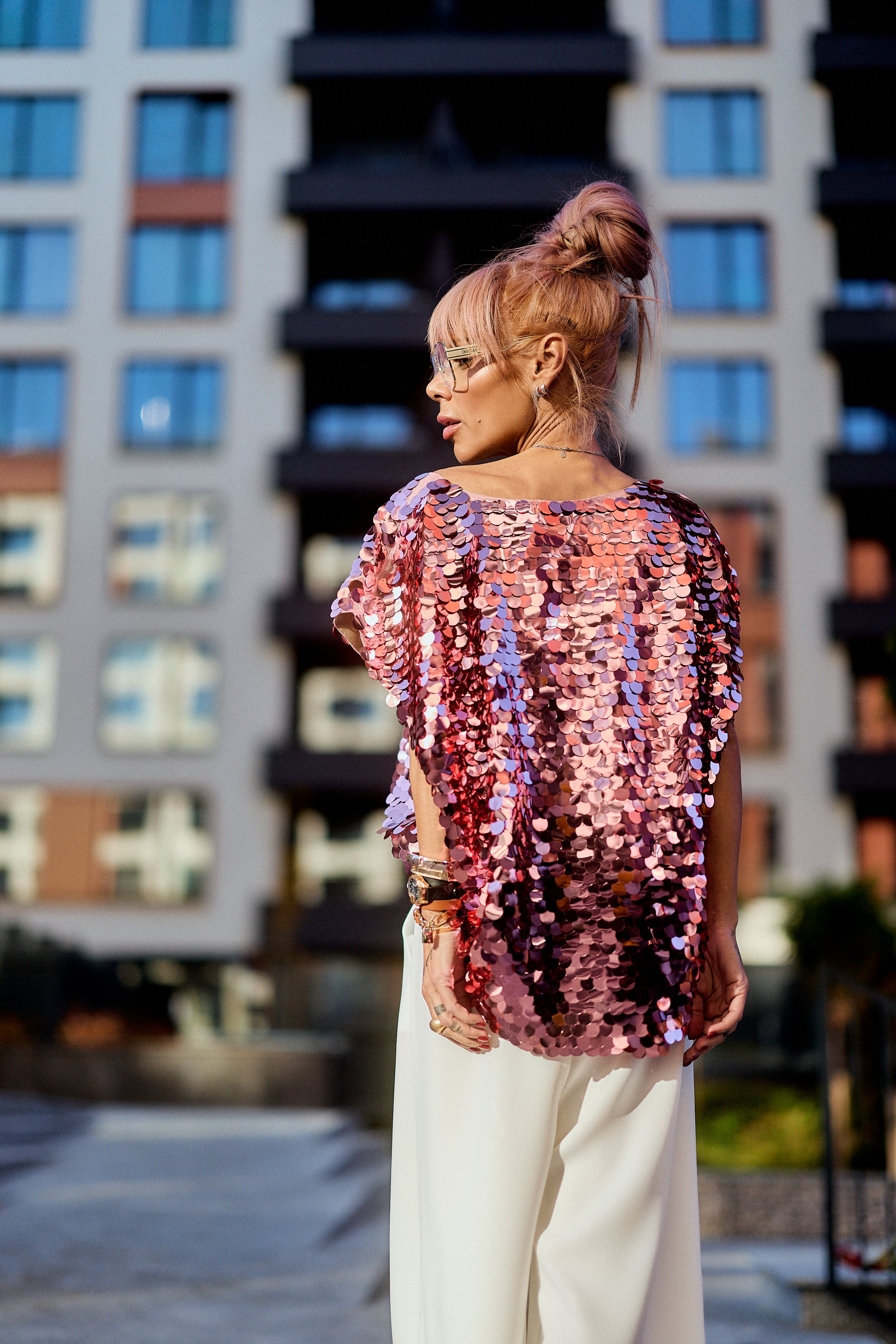 Model wearing a Pink Sequin Oversized Top with pink sequins shimmering against an urban backdrop.