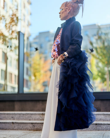 Denim Tulle Detail Blazer worn elegantly over a stylish outfit, showcasing the dramatic tulle ruffle detail.