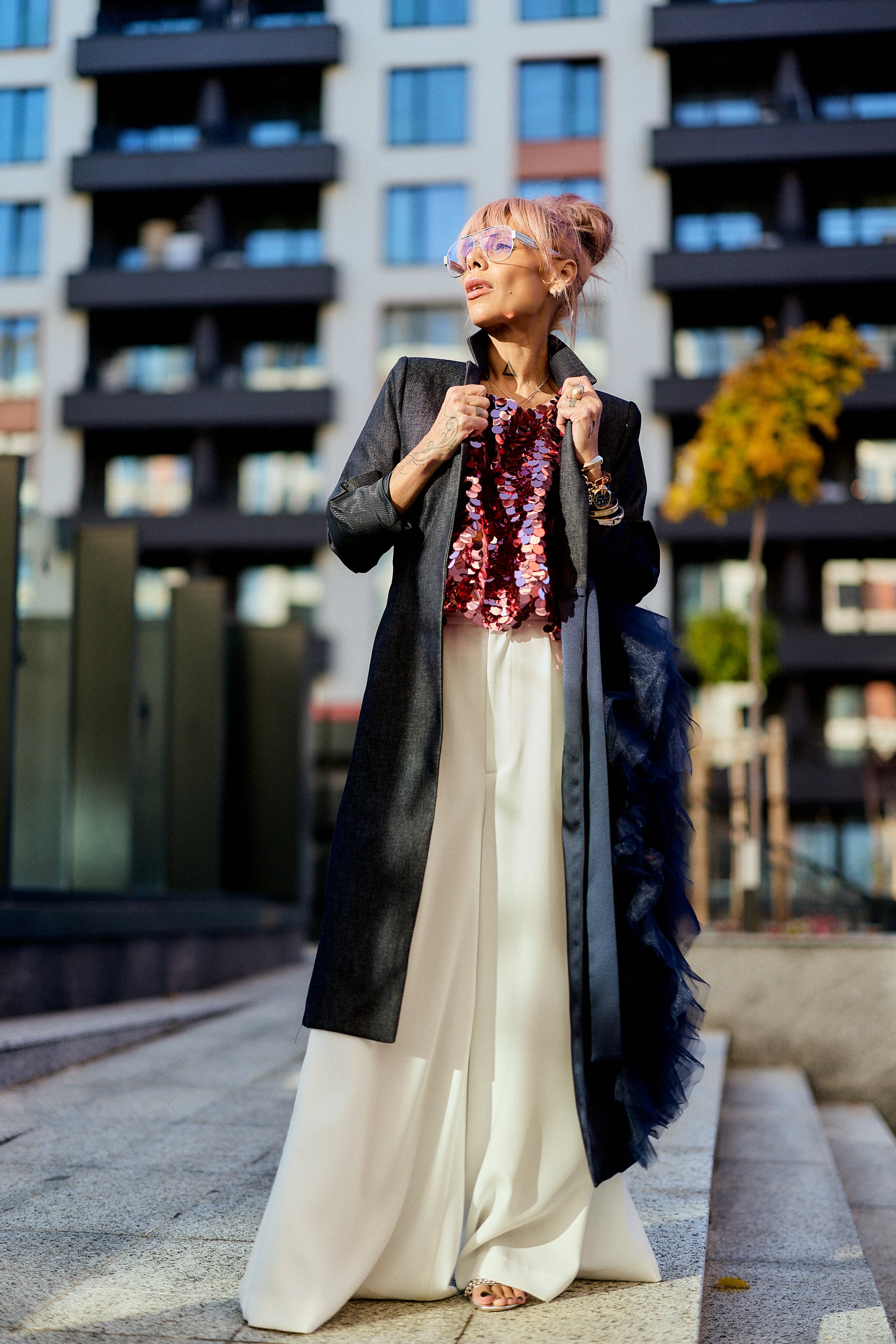 Woman wearing a Denim Tulle Detail Blazer with tulle ruffle, showcasing a modern urban style in an outdoor setting.